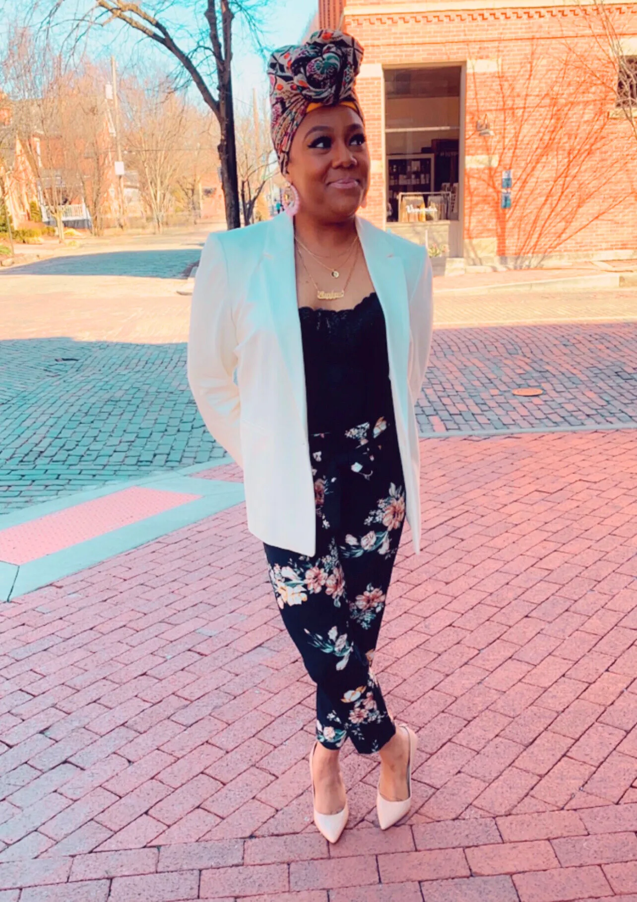 Exhibition artist Keya Crenshaw standing outside on a sidewalk, smiling and looking to her left.