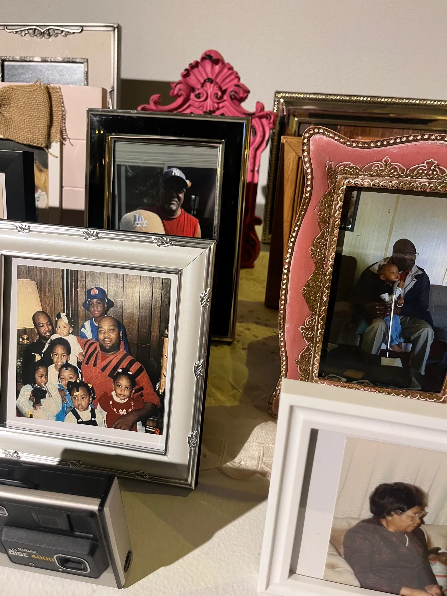 A close-up of Crenshaw’s family photos displayed in vintage and antique photo frames.