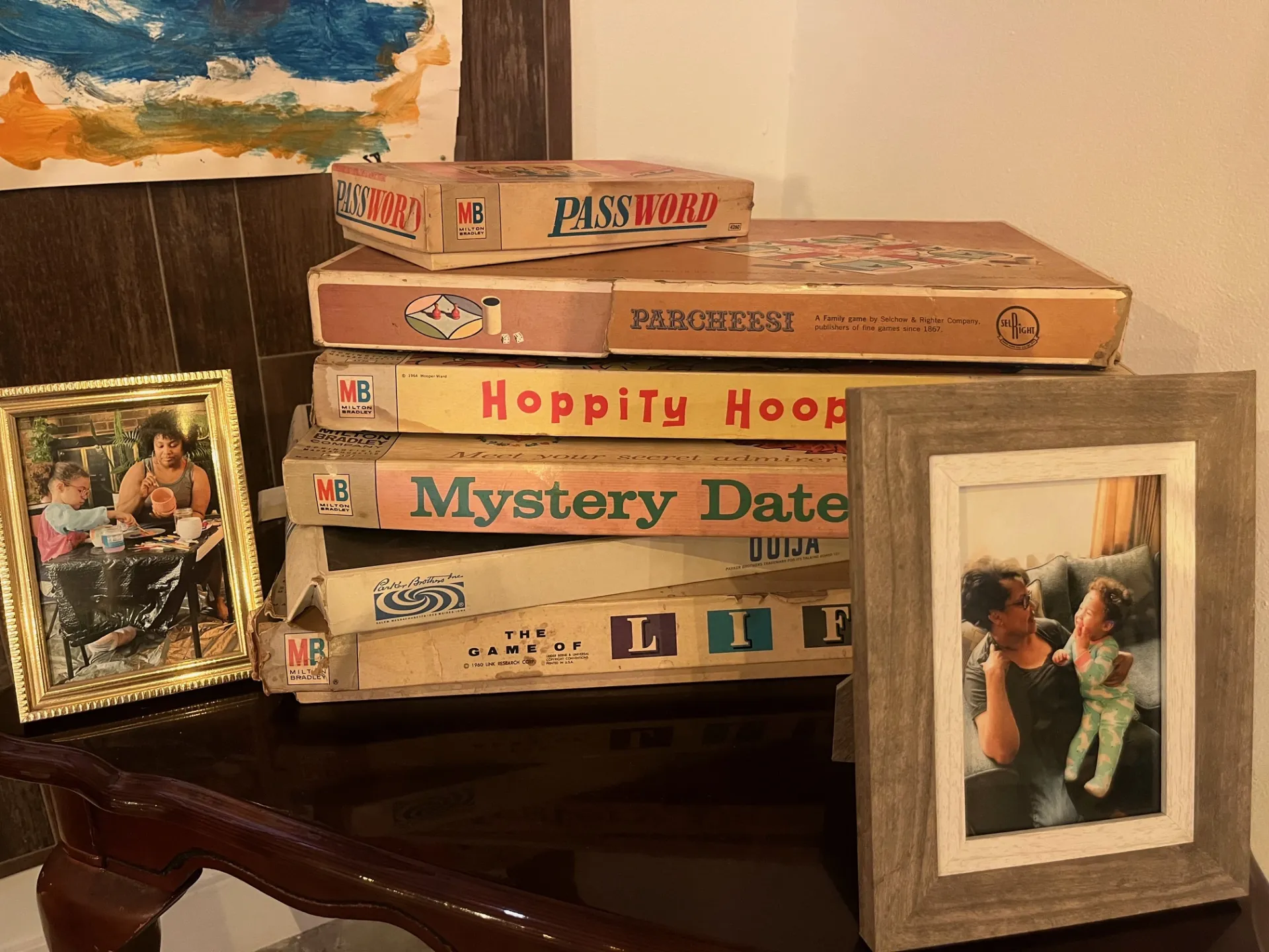 A stack of vintage board games with family photos on each side of the stack.