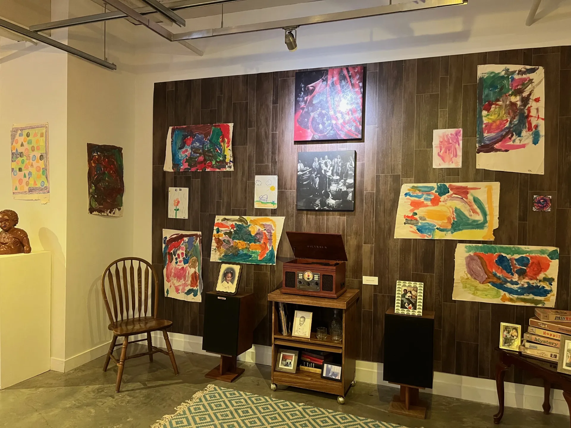 Children’s art portraits, painted by Crenshaw’s niece, decorate the wall above the Victrola record player.