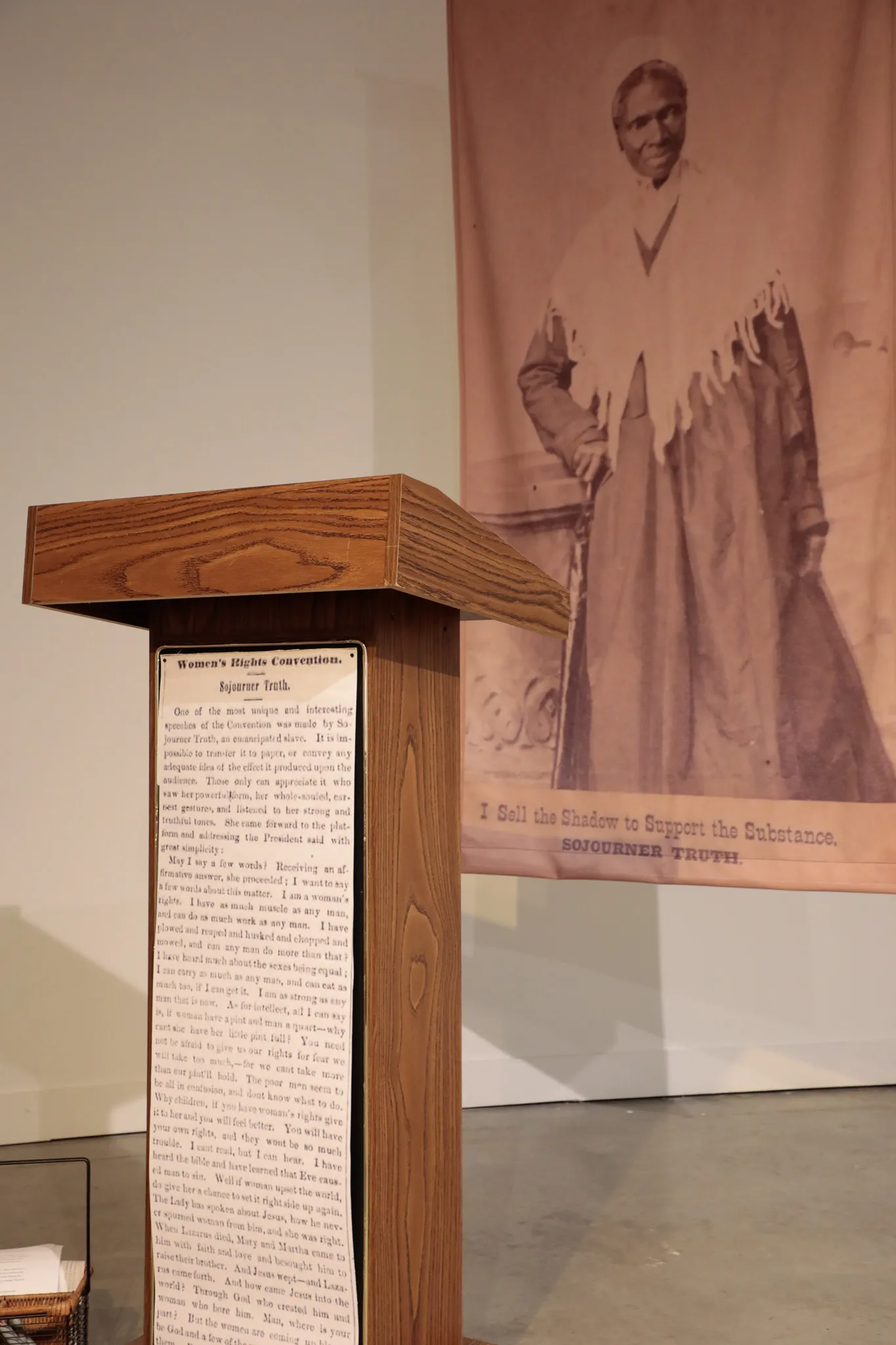 A banner with a photograph of Sojourner Truth stands behind a wooden podium