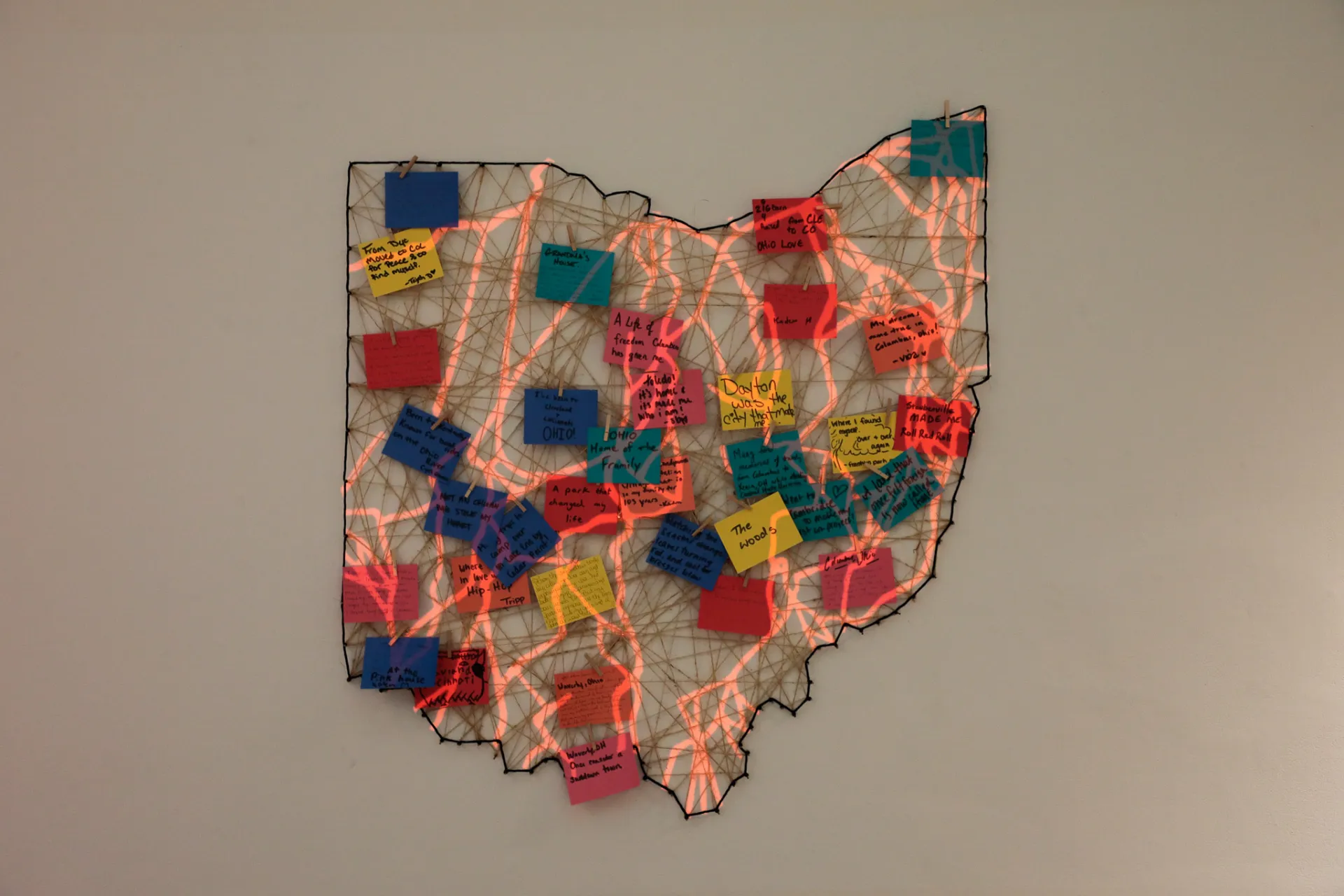 The state of Ohio has been created by wrapping twine around nails in the wall. Guests have attached notes with clothes pins. 