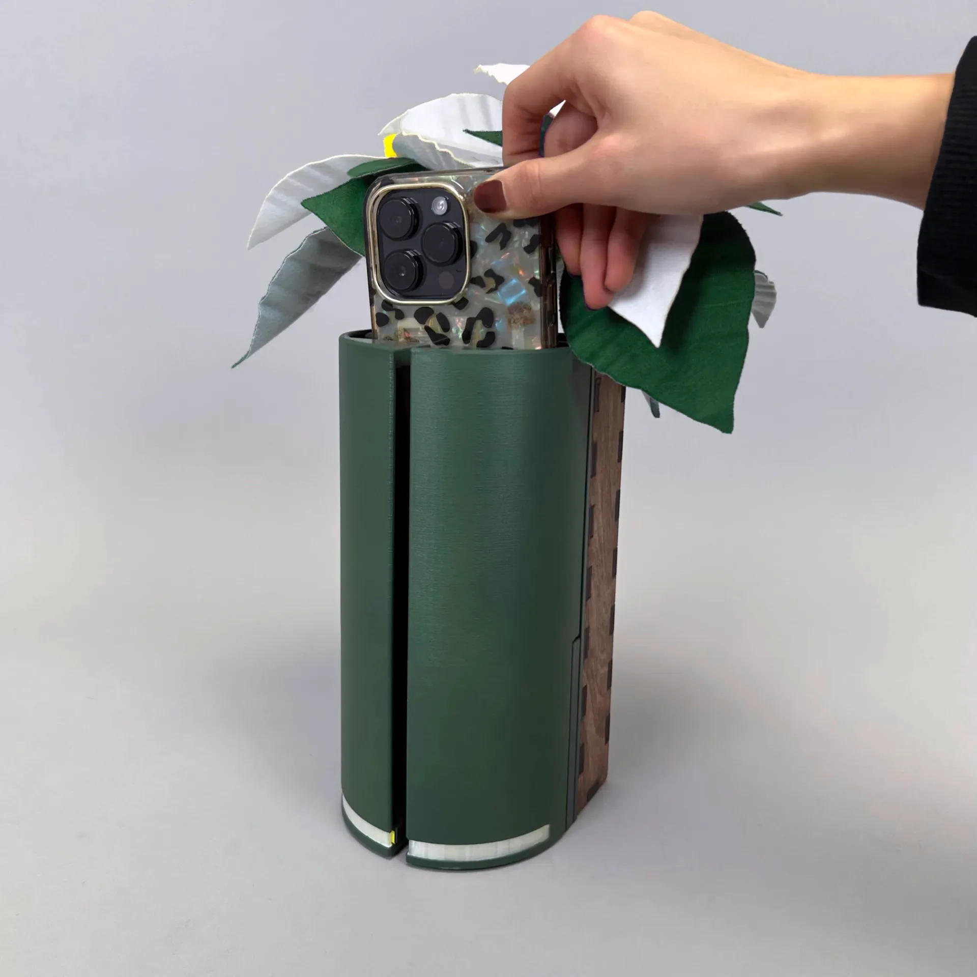 tall green container with felt flower used for holding a phone