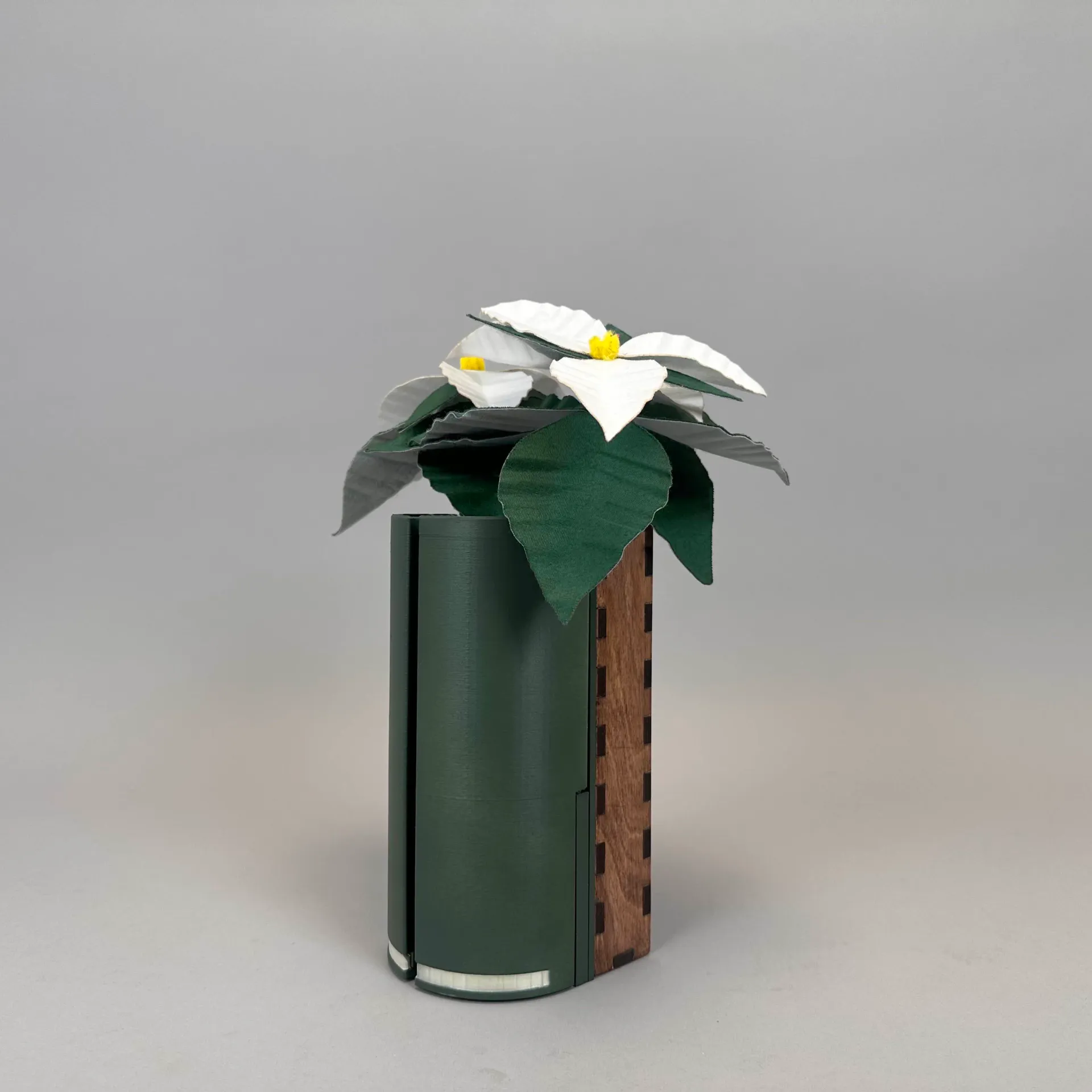 tall green container with felt flower used for holding a phone