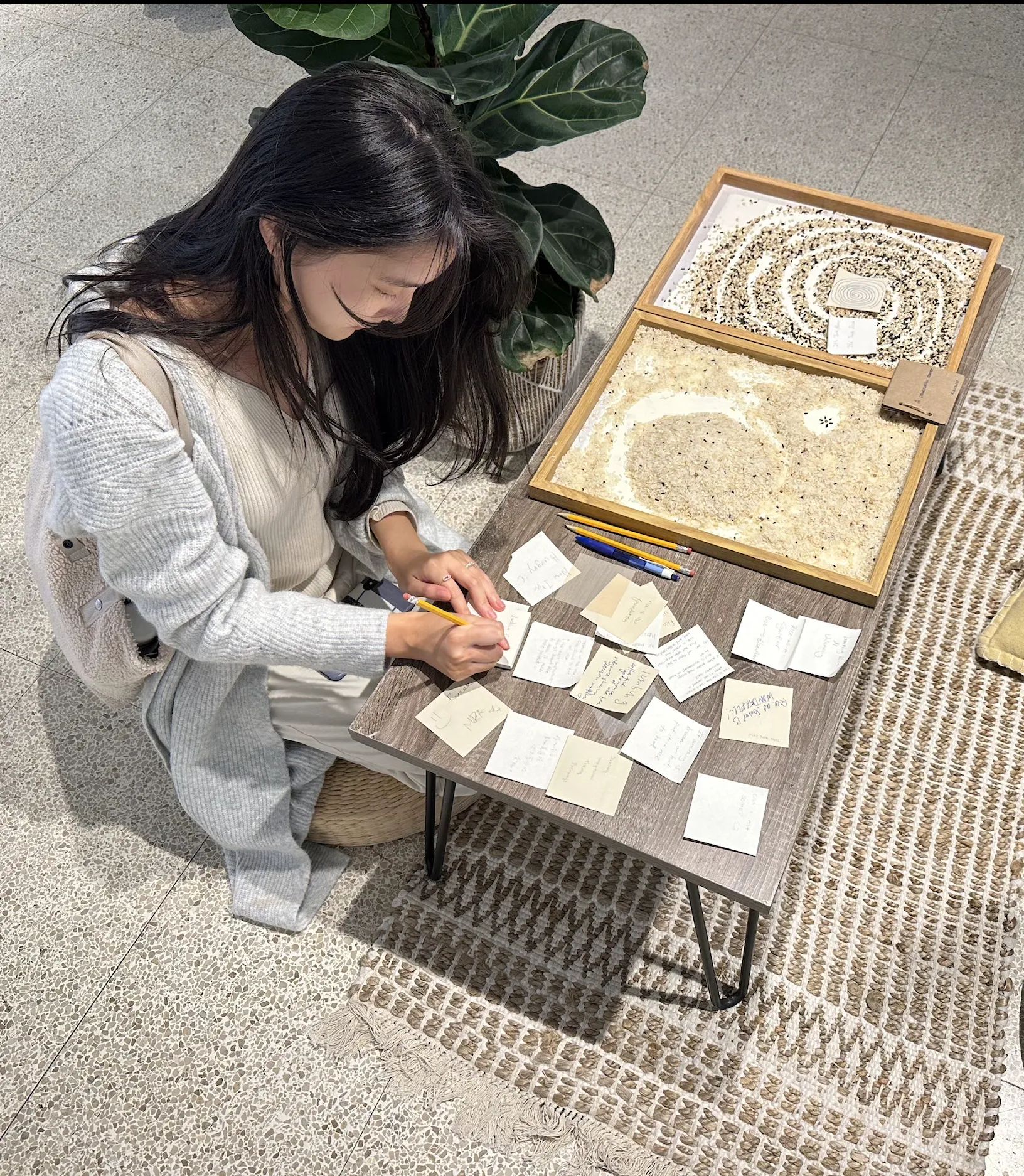 Xiaoxiao responding to visitors' notes at a low table