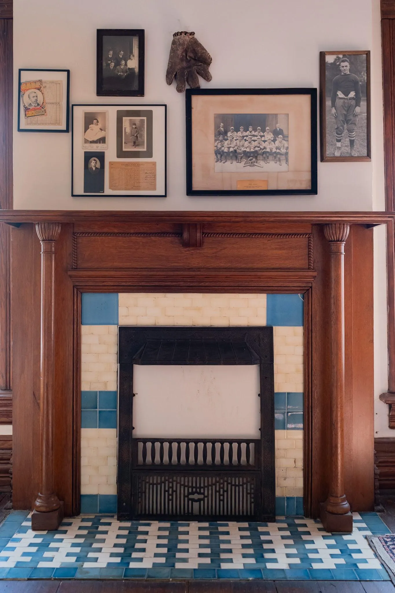 fireplace with blue and white tile and framed pictures above it