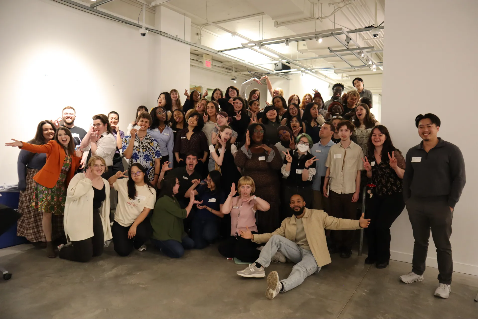 30+ members of Urban Arts Space staff and interns posing and smiling on the gallery steps