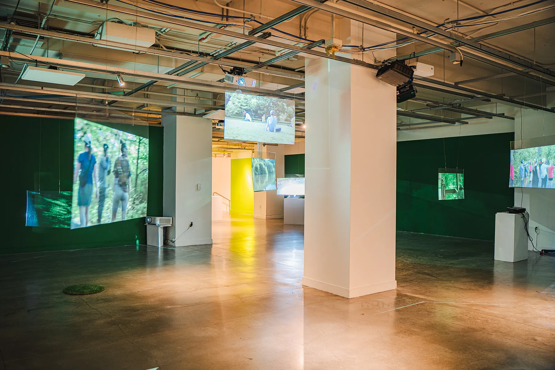 the gallery filled with hanging screens showing the park performances