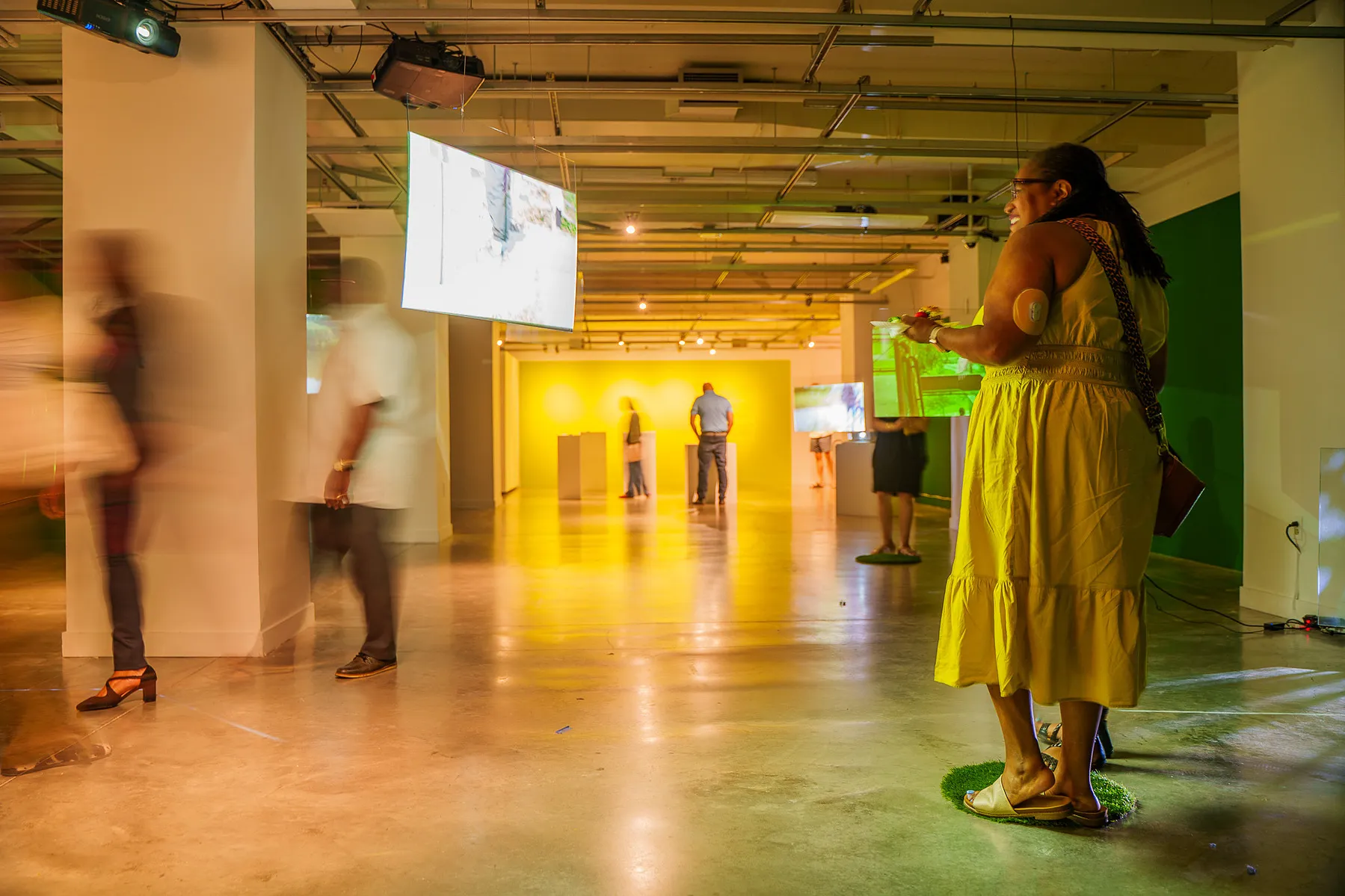 visitors looking at the video screens in the gallery exhibition