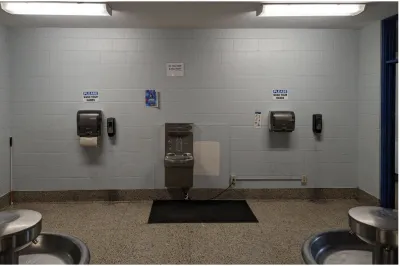 A blank brick wall outside of a school bathroom