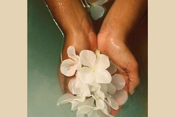 hands holding petals in water