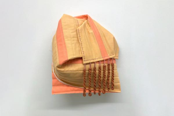 sculpture made from terra-cotta and cotton, a orange fabric is warped around a spherical object