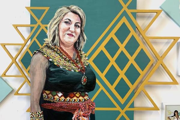 Painting of a woman in front of a gold geometric pattern
