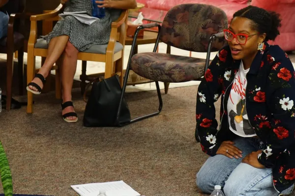 Ajanae kneeling on the floor with papers