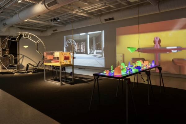 hopkins hall gallery with architectural installations, such as a large wheel and a table of small office furniture replicas