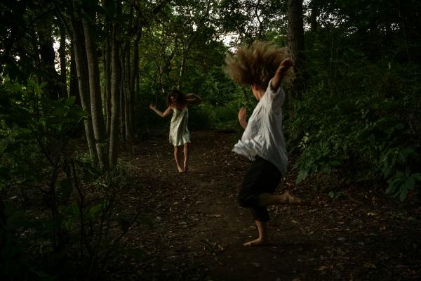 Two women dancing in a forest