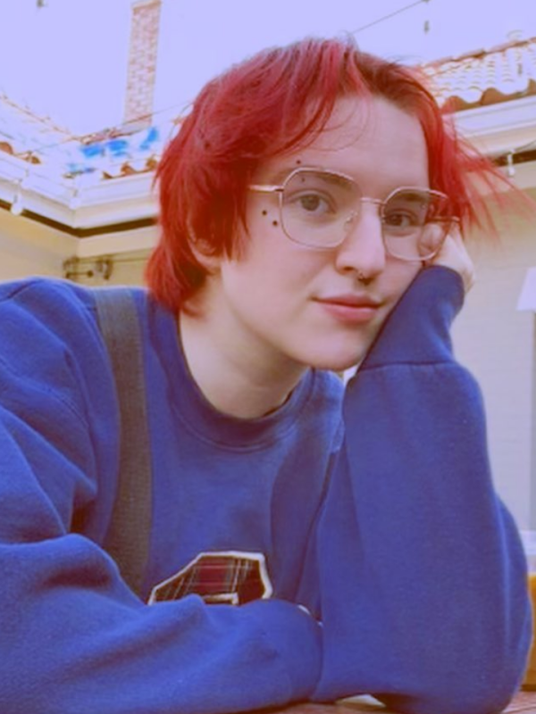 Photo of Levi with glasses, red hair, and a blue sweatshirt