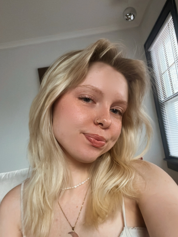 Emma with blonde hair and a crescent moon necklace