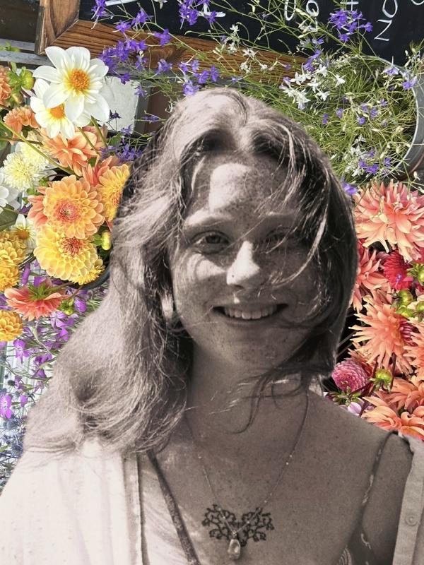 Black and white photo of Alicia smiling against a colorful background of flowers