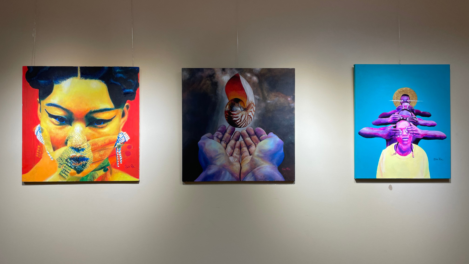 Three square paintings, with one that depicts an Asian woman with a see-through hand over her mouth, then two hands with a floating shell, and then a purple person holding their hands over their ears and the image repeating back