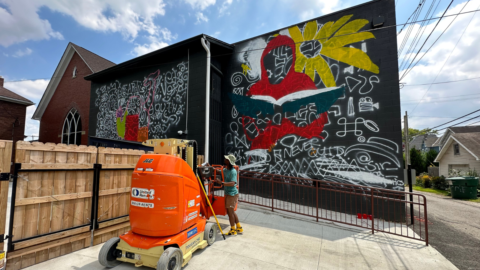 Arris' working on a large-scale mural on the back of Franklinton High School