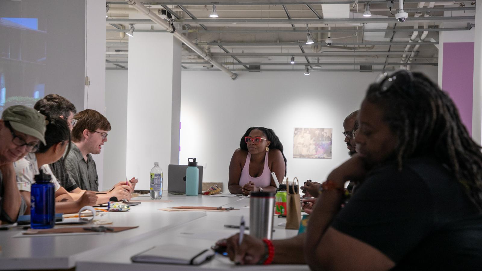 Ajanae at a table teaching a workshop