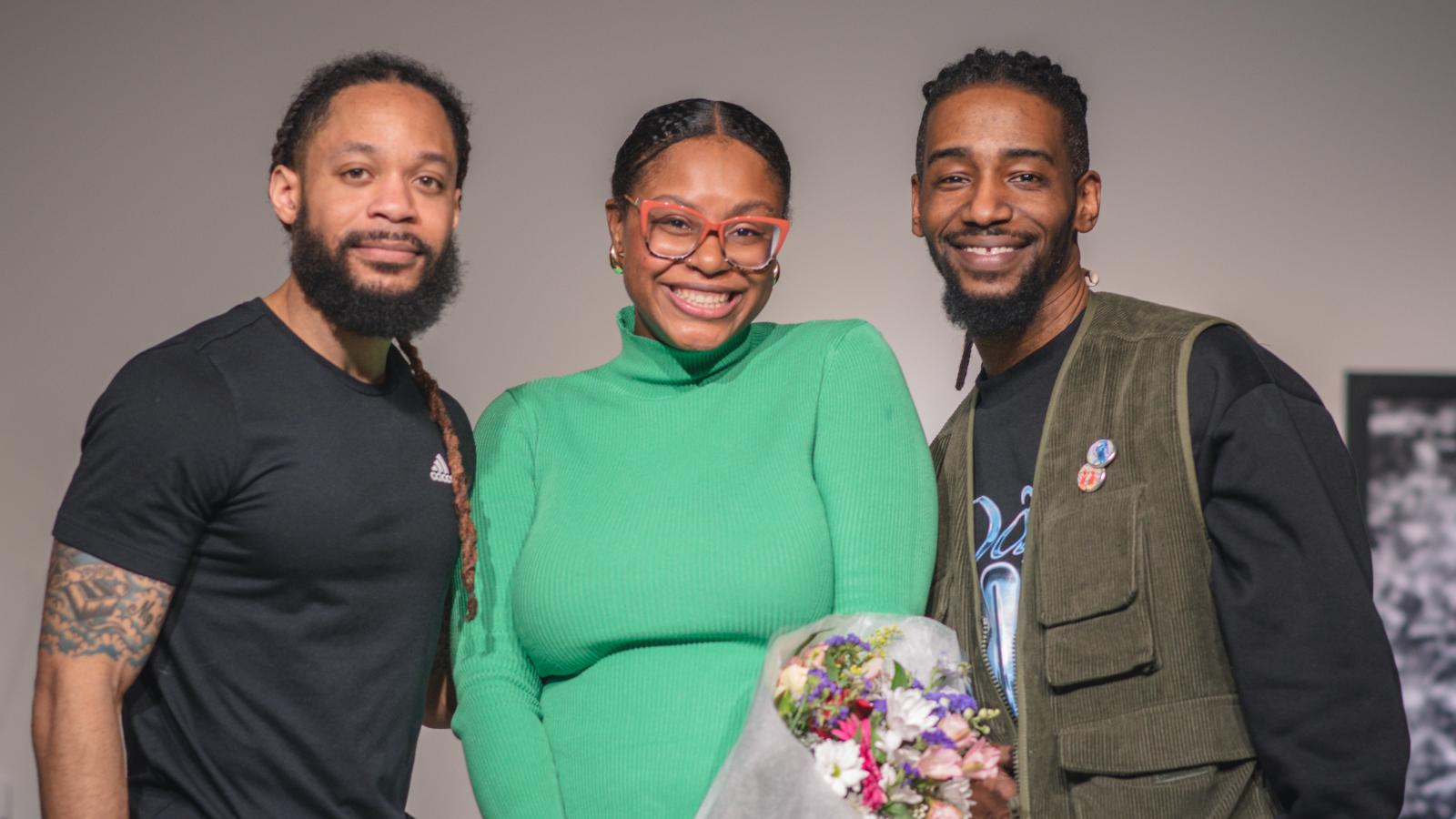 Ajanae in a green dress smiling with Dr. Terron Banner and Arris' Cohen