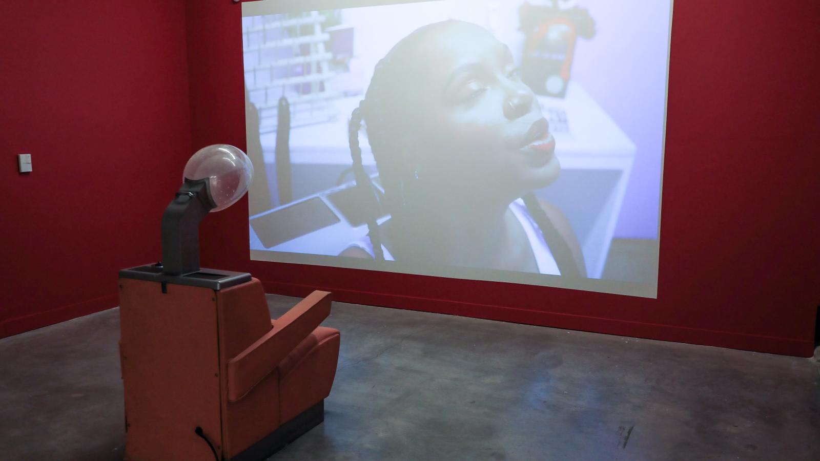 Video of Ajanae at the gallery with a barbershop chair