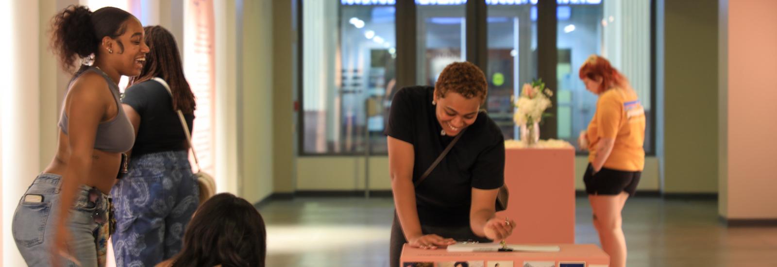 Several women writing and participating with the exhibition.