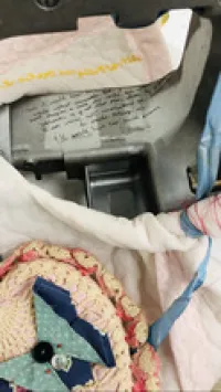 An aerial view of part of the assemblage. A corner of the sewing machine and colorful stitched fabric with a bow are visible.